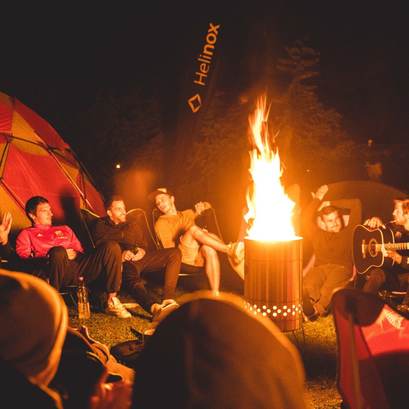a group of people sitting around a fire